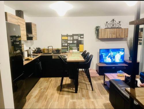 Il comprend une cuisine et un salon avec une table et une télévision. dans l'établissement Mon cocon, à Furiani