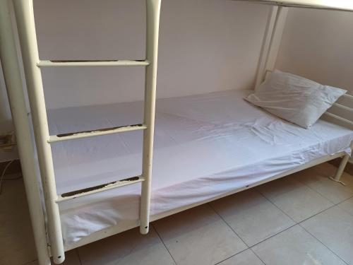 a bunk bed with white shelves in a room at A room in an apartment in Nasr City, Cairo, near Azhar university , 15 minutes from Cairo Airport,غرفة بشقة بمدينة نصر بالقاهرة بالحي الثامن 15 دقيقة من مطار القاهرة و 7 دقيقة من معهد الفجر و 12 دقيقة لمعهد ابانة لتعليم اللغة العربية و 26 دقيقة لوسط البلد in Cairo
