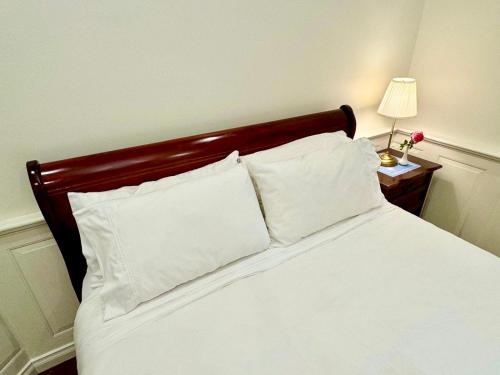 a bedroom with a bed with white sheets and pillows at Charming Federation style home minutes from CBD in Perth