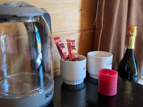 a counter with a blender and cups and a bottle of wine at Thethi Villas in Theth