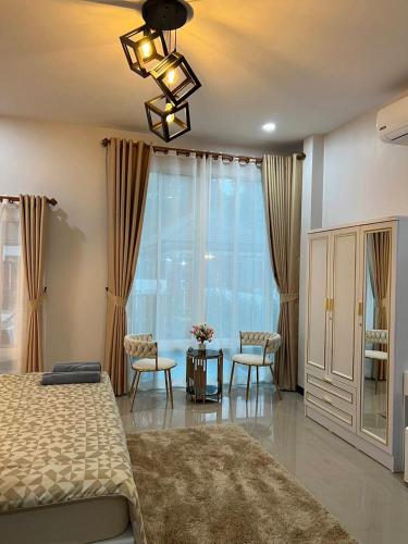 a bedroom with a bed and a table and chairs at Cherina Pool Villa 3 in Hat Yai