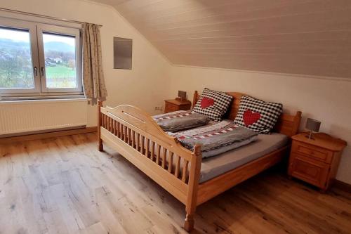 a bedroom with a wooden bed and a window at Time Out Moments Haus mit eigener Sauna in Grafenau