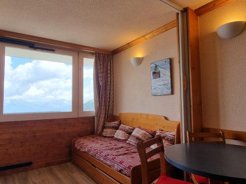 Cette petite chambre comprend un canapé et une fenêtre. dans l'établissement Studio agréable avec accès direct aux pistes et coin montagne - FR-1-181-2583, à Aime La Plagne