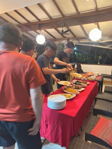 a group of people standing around a table with food at Liberty Guesthouse Maldives in Mahibadhoo