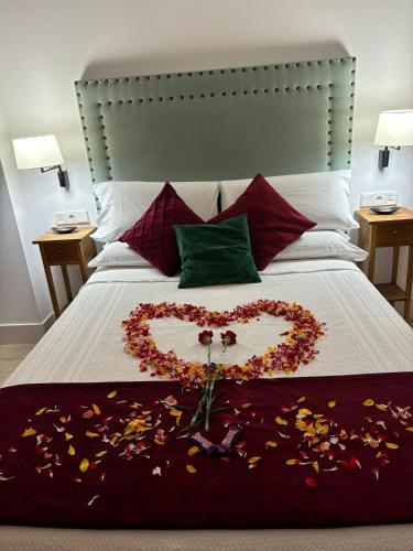 a heart made out of flowers on a bed at Apartamentos Turísticos La Plaza in Chipiona