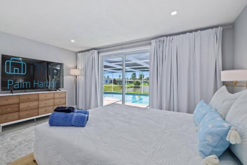 Un dormitorio con una cama y un televisor y una ventana. en Infinity Retreat, en Port Richey