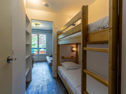 Cette chambre comprend 2 lits superposés et une porte. dans l'établissement Studio rénové avec balcon, parking et proche pistes à Val-d'Isère - FR-1-694-287, à Val dʼIsère