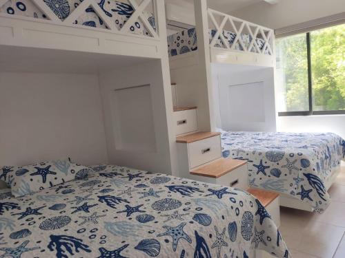 a bedroom with two beds and a bunk bed at Casa entera de lujo Playa del Carmen in Playa del Carmen