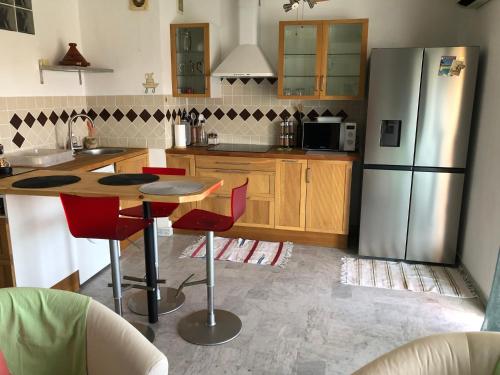 une cuisine avec une table et un réfrigérateur dans l'établissement Coquet studio avec grande terrasse, à Antibes