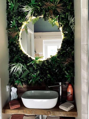 une salle de bain avec un miroir et un lavabo dans l'établissement Hors du temps, Suites Romantiques, à Campremy