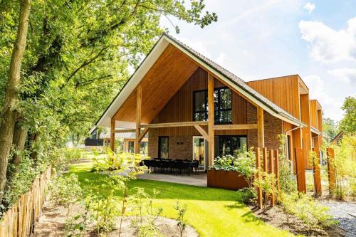 a home with a wooden house with a garden at Veluwe Villa with Indoor Pool & Wellness | 12 persons in Wekerom