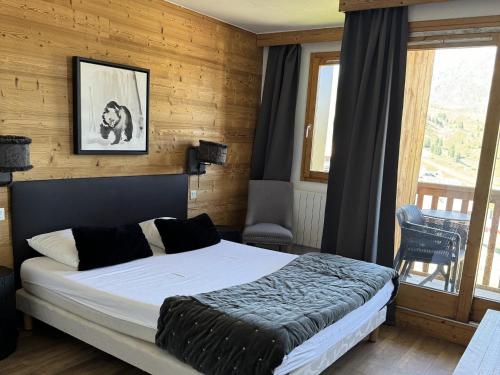 une chambre avec un lit dans une pièce aux murs en bois dans l'établissement Spacieux 4P, Ski aux Pieds, Sud-Ouest, Piscine/Spa, Belle Plagne - FR-1-181-2809, à La Plagne Tarentaise