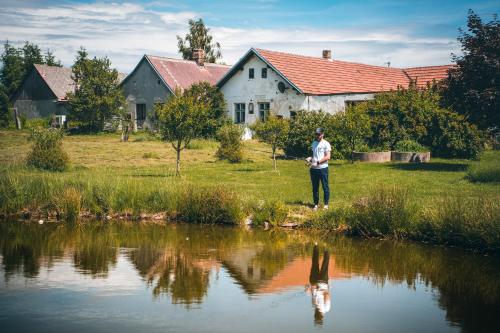 a man standing next to a body of water at Apartmán Na Vrších in Nový Bozděchov