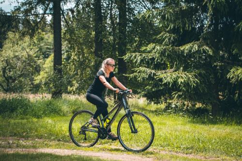 a woman riding a bike on a path at Apartmán Na Vrších in Nový Bozděchov