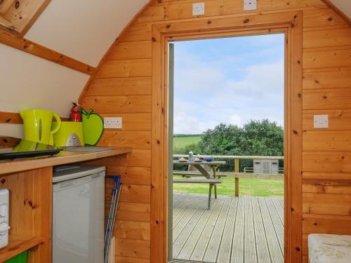 a kitchen with a door leading to a deck at Fox Den Penbugle Organic Farm in Liskeard