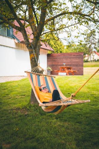a man laying in a hammock in a yard at Apartmán Na Vrších in Nový Bozděchov