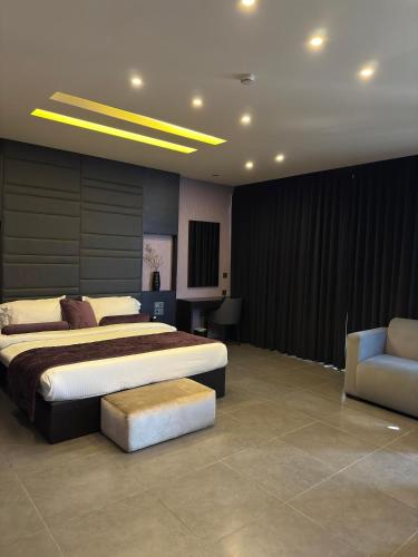 a bedroom with two beds and a couch and a chair at Louis V Hotel Beirut in Beirut