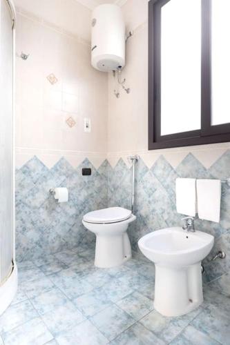 a bathroom with a toilet and a sink at House 320 in Comiso