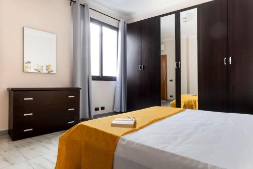 a bedroom with a large bed with a yellow blanket on it at House 320 in Comiso