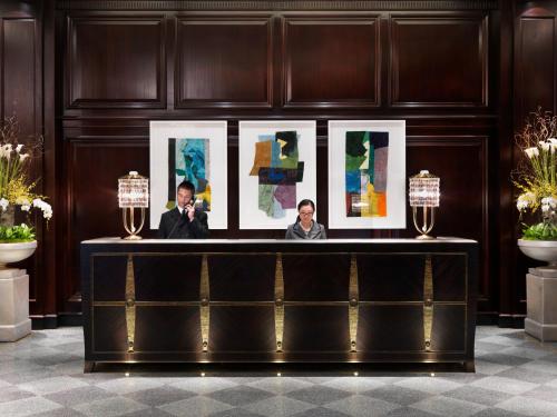 two men standing next to each other in front of a painting at Rosewood Hotel Georgia in Vancouver