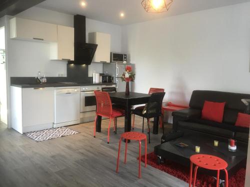 une cuisine et un salon avec une table et des chaises dans l'établissement Appartement t3 calme avec jardin privé, à Anglet