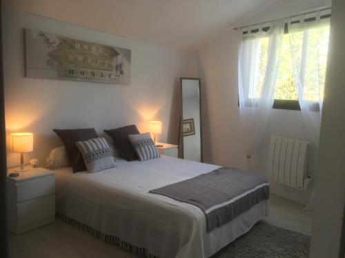une chambre avec un grand lit et une fenêtre dans l'établissement Appartement t3 calme avec jardin privé, à Anglet
