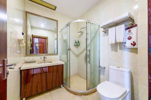 a bathroom with a shower and a toilet and a sink at JC Hotel in Guangzhou