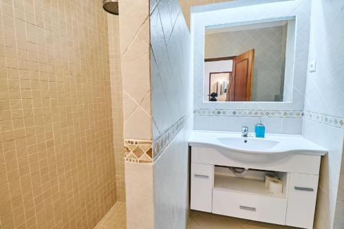 ein Badezimmer mit einem weißen Waschbecken und einem Spiegel in der Unterkunft Apartment Dean direkt am Meer in Armação de Pêra