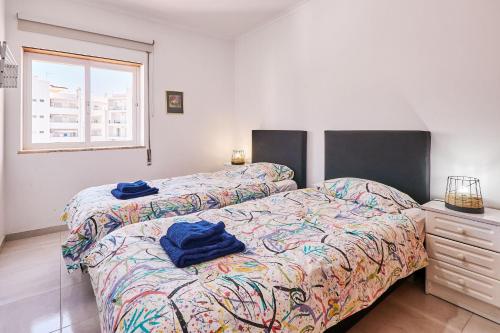 1 Schlafzimmer mit 2 Betten, einer Kommode und einem Fenster in der Unterkunft Apartment Dean direkt am Meer in Armação de Pêra