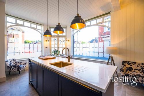 eine Küche mit Spüle und zwei großen Fenstern in der Unterkunft Dragon Court - 4 Beds with Terrace Garden in Henley on Thames