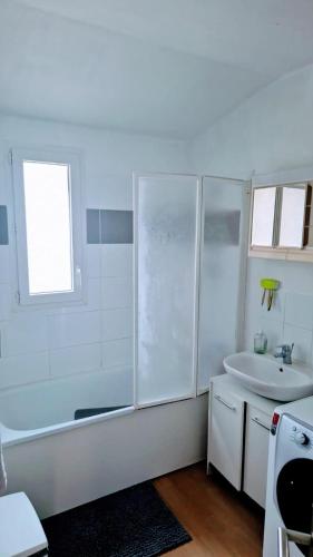 une salle de bain blanche avec une douche et un lavabo dans l'établissement Votre maison loin de chez Vous !, à Chanteloup-les-Vignes