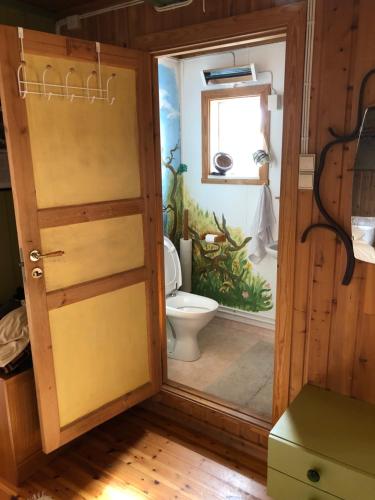 ein Badezimmer mit Toilette und Fenster in der Unterkunft Pasvik Taiga in Skogfoss