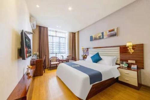 a bedroom with a large white bed in a room at JC Hotel in Guangzhou