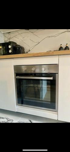 un four en acier inoxydable dans une cuisine blanche dans l'établissement Suite moderne au cœur du 8e, à Paris