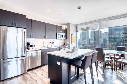 una cocina con armarios negros y una mesa con sillas en Luxury Apt with Balcony In Seaport, en Boston