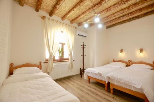 a bedroom with two beds and a window at Sarrof Guest House in Bukhara