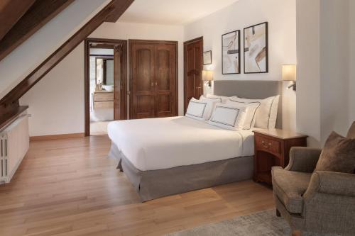 a bedroom with a white bed and a chair at Meliá de Tredós in Tredós