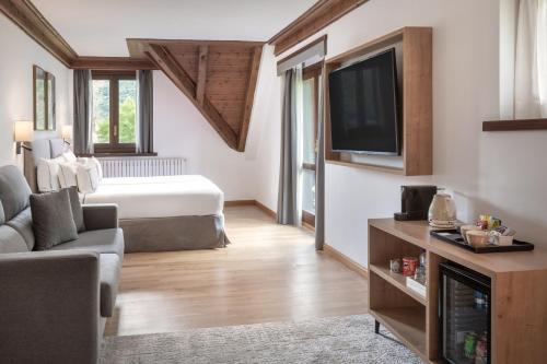 a room with a bed and a tv and a couch at Meliá de Tredós in Tredós