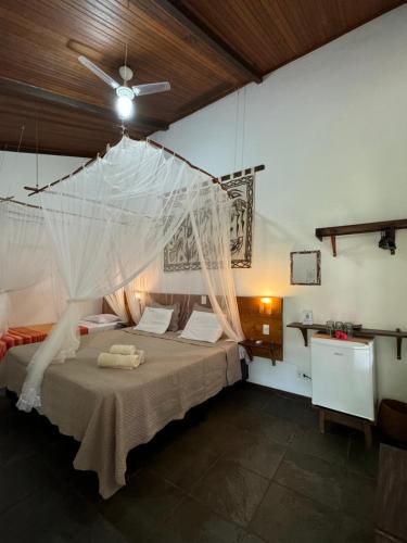 a bedroom with a bed with a mosquito net at Pousada Horizonte Azul in Ilha de Boipeba