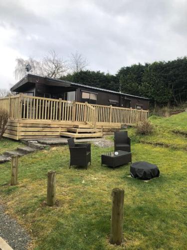 a yard with two chairs and a house at 5f Stanley Lodge, Caer Beris, Builth Wells - No tradesman in Builth Wells