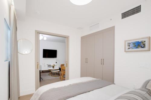 a white bedroom with a bed and a mirror at Vonder Miami Beach - Unit 7 in Miami Beach
