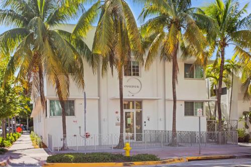 a white building with palm trees in front of it at Vonder Miami Beach - Unit 7 in Miami Beach