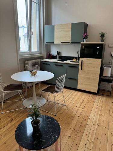 - une cuisine avec une table et des chaises blanches dans la chambre dans l'établissement OSLO, hyper centre, proche gare, marché Boulingrin, à Reims
