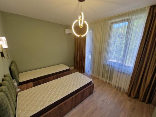 a bedroom with two beds and a chandelier at Villa-Riverside in Ch'aisubani