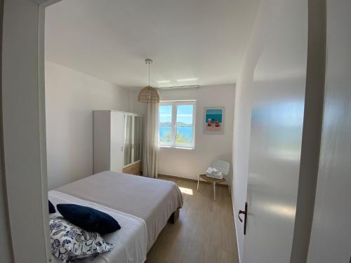 a small bedroom with a bed and a window at SEASPRAY APARTMENTS TISNO in Tisno