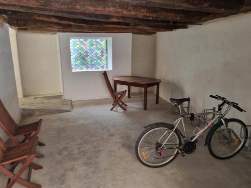 a bike parked in a room with a table and a window at Fenêtre sur cour du Docteur Privey - Secure Park Bike - 3 mn Autoroute in Tournus
