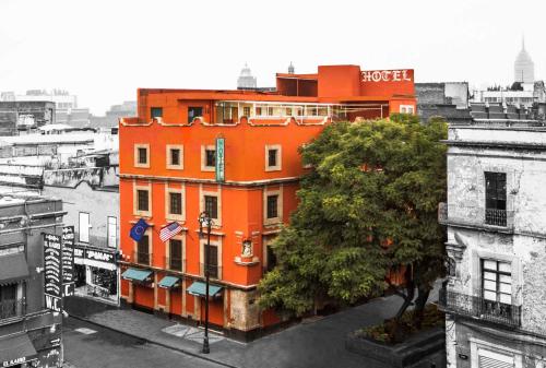 an orange building with a tree in front of it at Hotel Templo Mayor in Mexico City