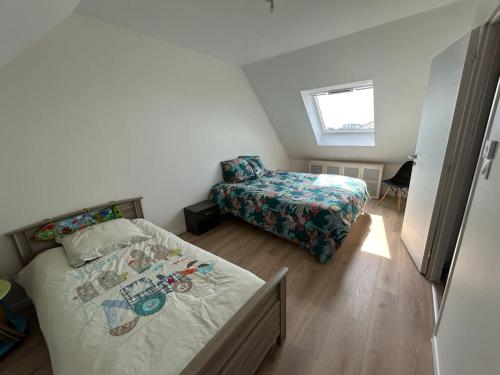 ein kleines Schlafzimmer mit zwei Betten und einem Fenster in der Unterkunft En famille ou amis avec la mer in Équihen-Plage