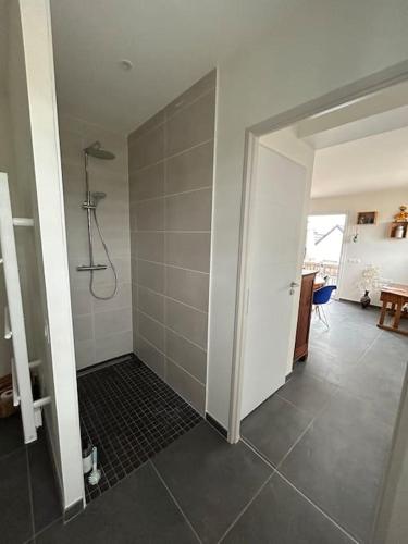 La salle de bains est pourvue d'une douche et de carrelage. dans l'établissement En famille ou amis avec la mer, à Équihen-Plage