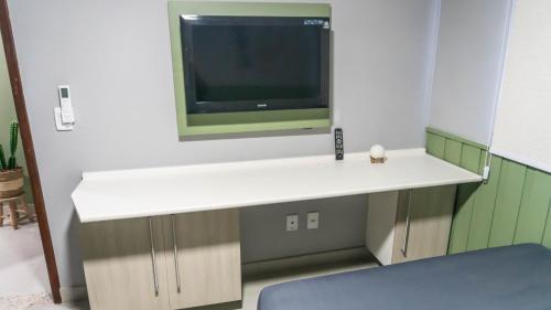 a room with a white counter with a tv on the wall at Residencial Marina clube D205 in São Pedro da Aldeia